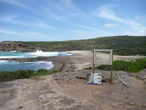 Vandalized sign on the Coastal walk with Pinney's Beach in the distance